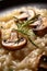 A plate of mushroom risotto with a sprig of rosemary. Generative AI image.