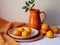 plate with oranges on table with orange tablecloth and orange ceramic jug
