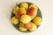 A plate overflowing with delicious ripe pears on a white shelf viewed from the top