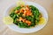 Plate of parsley and tomato tabbouleh with lemon wedges