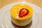 Plate of Passion Fruit Cheese Cake Topped with Fresh Strawberry