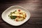 Plate of pasta with asparagus and spinach over wooden background