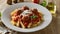 A plate of pasta with meatballs and cheese