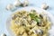 Plate of pasta with mushrooms and cheese, sprig of Basil, fresh mushrooms