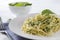 Plate of pasta, spaghetti with spinach, fork on a white background close-up
