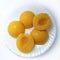 Plate of peeled and chopped peaches isolated on a white background. Canned peaches on a white plate. View from above
