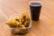 A plate of picarones with chicha morada at a street food market festival.