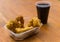 A plate of picarones with chicha morada at a street food market festival.