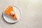 Plate with piece of fresh delicious homemade pumpkin pie on gray background, top view