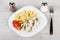 Plate with pieces chicken, pasta and tomatoes, fork