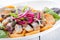 Plate of pieces of herring with fried potato,onion and salad. Close up image with selective focus