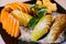 a plate with pieces of pear, apple and orange with powdered sugar and mint.