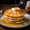 A plate piled with fluffy golden pancakes