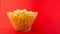 A plate of popcorn on a red background. the concept of film viewing, rest on the weekend, with space