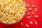 Plate with popcorn on a red background. layout. top view. concept of cinema, viewing, rest