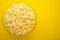 Plate with popcorn on a yellow background. layout. top view. concept of cinema, viewing, rest