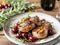 On a plate of pork chops in wine with cherries