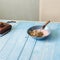 Plate porridge with yogurt on blue wooden table. Healthy breakfast