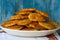 Plate with potato pancakes, blue wood background, close-up