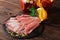 A plate of prosciutto with fresh green leaves of mint, a glass of fruit beverage and orange on a wooden background.