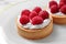 Plate with raspberry tarts. Delicious pastries