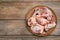 Plate with raw chopped meaty bones on wooden table, top view. Space for text