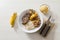 Plate of rice, beans, steak and cassava. With cutlery and manioc flour and banana for dessert.