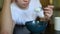 Plate with rice porridge. Teen lazily picking porridge with a spoon