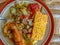 A plate of rice with a side dish of fried tempeh plus tamarind vegetables and fried chicken.