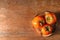 Plate with ripe persimmons on wooden table, top view