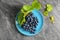 Plate with ripe sweet grapes on grey textured background