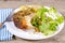 Plate of roast chicken, crisps and green salad