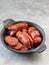 Plate of roasted sausages on kitchen table.