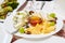 A plate with a set of different cheeses: Mazda, Parmesan, Blue Cheese, served with fruits.