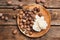 Plate with shea butter and nuts on wooden background