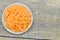 Plate with short stick carrots on wooden table, closeup