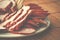 A plate of sliced ham, smoked sausage and cheese on table background.