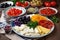 plate of sliced ingredients, ready for cooking: cheese slices, tomatoes, olives and other items