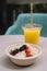 plate of sliced â€‹â€‹fruits like an acai bowl accompanied by a natural juice