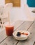 plate of sliced â€‹â€‹fruits like an acai bowl accompanied by a natural juice