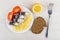 Plate with slices of smoked mackerel, lemon, tomato, bread