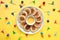 Plate of small round pancakes with colorful party topper flags on split three color layered paper background. Top view