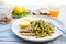 plate of spelt pasta, pesto, slices of grilled chicken, and lemon wedge