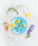Plate with spring flowers, fork, sign and decoration on gray wooden background, top view