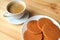 Plate of Stroopwafel Cookies, Tasty Dutch Traditional Sweets served on wooden table with a Cup of Hot Coffee