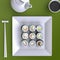 Plate with sushi, chopsticks and tea cup. View from above.