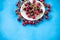 Plate with sweet cherries closeup. Freshly harvested summer berry on blue background. Vitamin containing ripe fruits