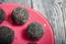 Plate with sweets coated with sesame seeds. Candies in the form of balls lie on a plate. On brushed pine boards