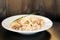 Plate of tagliatelli carbonara italian food in a rustic restaurant setting