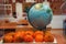 Plate of tangerines and model globe on the bench